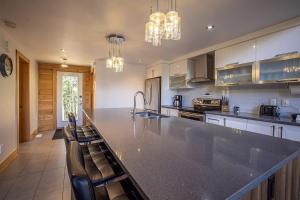 a large kitchen with a large counter and chairs at Chinook 172 in Sainte-Marguerite +41 photos