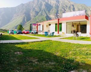 a building with cars parked in front of a mountain at Eden Garden Resort Batakundi in Naran