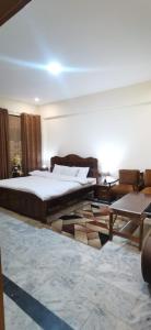 a bedroom with a large bed and a table at Eden Garden Resort Batakundi in Naran