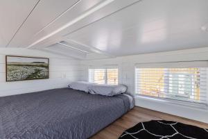 a bedroom with a bed and two windows at Zion Basecamp Private Hot Tub Near Trails in Apple Valley