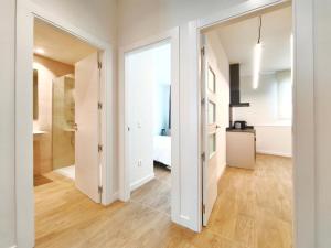a hallway with white walls and wood flooring in a apartment at Apartamentos Mantería Lacort, Valladolid in Valladolid +229 photos