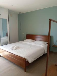 a bed with white sheets and a mirror in a bedroom at OCEAN Hotel Miami in Toamasina