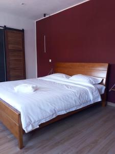 a bedroom with a large bed with a wooden headboard at OCEAN Hotel Miami in Toamasina