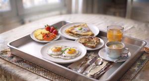 a tray with four plates of breakfast food on it at OCEAN Hotel Miami in Toamasina