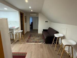 a living room with a couch and a table and stools at Casa Marza in Făgăraş +2 photos