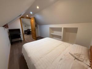 a bedroom with a large white bed and a piano at Casa Marza in Făgăraş