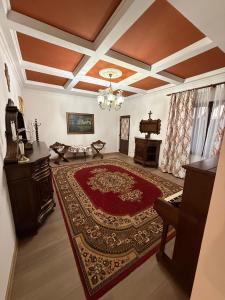 a living room with a red rug and a piano at Casa Marza in Făgăraş