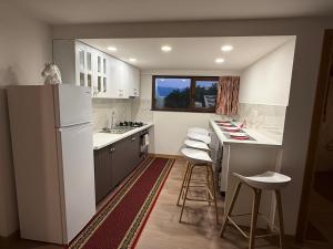 a kitchen with a refrigerator and a counter with stools at Casa Marza in Făgăraş