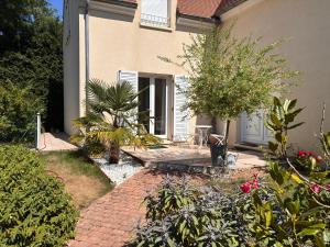 a garden with a brick walkway in front of a house at Orée de Villevert in Senlis