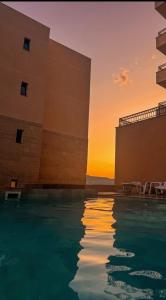 a swimming pool with a sunset in the background at Iva Apartment in Kumbor
