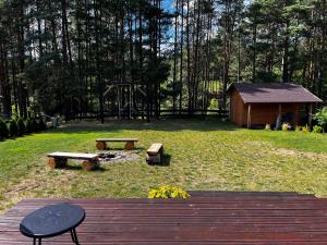 a wooden deck with a picnic table and a playground at Osada Rolbik in Leśno