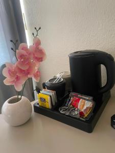 a black tray with a coffee cup and flowers on a counter at Hotel Am Flughafen in Cologne