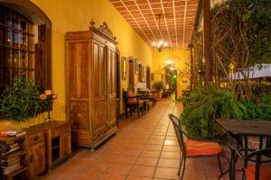 a hallway with tables and chairs in a restaurant at Hotel Casa Antigua by AHS in Antigua Guatemala