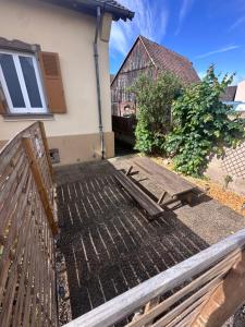 a wooden bench in front of a house at Les grumeaux Colmar Est in Horbourg