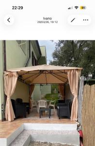 a patio umbrella with a table and chairs under it at Casa Elisa in Padru