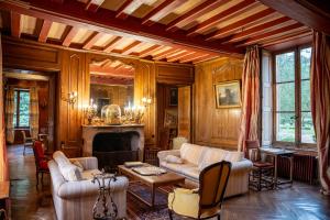 a living room with couches and a fireplace at Château De Chambiers in Durtal
