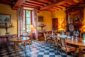 a dining room with wooden tables and chairs at Château De Chambiers in Durtal