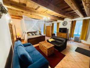 a living room with a blue couch and a bed at Zázrak Wellness in Banská Štiavnica