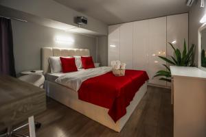 a bedroom with a large bed with red pillows at Vake Dream Duplex in Tbilisi City