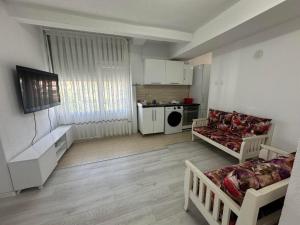 a living room with a couch and a kitchen at Nart Apartament in Prizren
