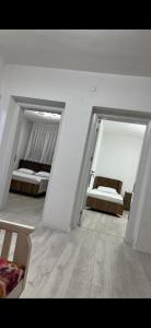 a white room with two beds and a couch at Nart Apartament in Prizren