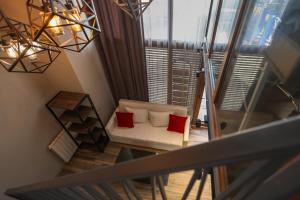 a living room with a white couch and red pillows at Vake Dream Duplex in Tbilisi City