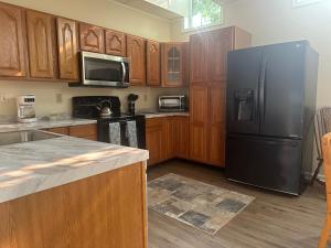 a kitchen with a black refrigerator and wooden cabinets at Inn at the Old Silk Mill in Fredericksburg