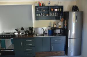 a kitchen with blue cabinets and a stainless steel refrigerator at Casa Bista Montaña in Barber