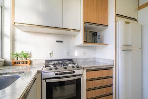 a white kitchen with a stove and a sink at Charming apartment in downtown Floripa EDC402 in Florianópolis