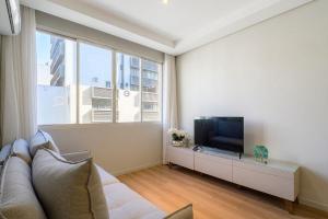 a living room with a couch and a flat screen tv at Charming apartment in downtown Floripa EDC402 in Florianópolis +15 photos