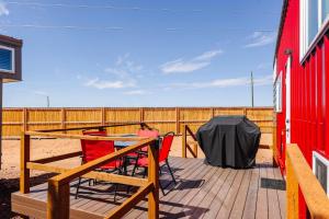 a deck with a table and chairs and a red building at Zion Basecamp Private Hot Tub Near Trails in Apple Valley +26 photos