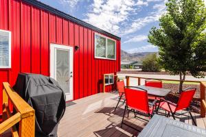 a red building with a table and chairs on a deck at Zion Basecamp Private Hot Tub Near Trails in Apple Valley