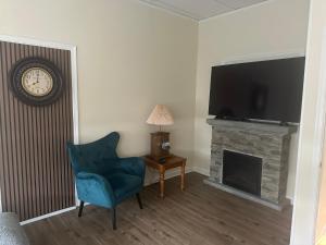 a living room with a blue chair and a fireplace at Inn at the Old Silk Mill in Fredericksburg