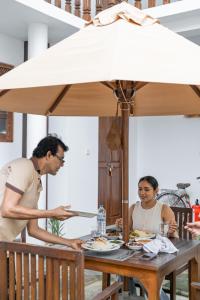 two people sitting at a table under an umbrella at Arches Fort in Galle