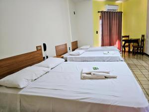 two beds in a hotel room with towels on them at Hotel Vivenda das Cachoeiras in Brotas