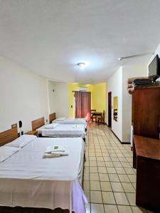 a hotel room with four beds and a table at Hotel Vivenda das Cachoeiras in Brotas +50 photos