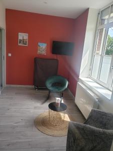 a living room with a green chair and a table at Cocon lumineux Euratech-CHU in Lille