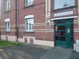 a brick building with a green door on it at Cocon lumineux Euratech-CHU in Lille