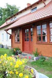 a house with a red door and some flowers at Bocianówka 5 in Wężówka