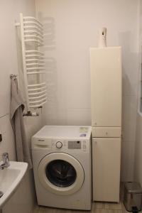 a washing machine in a bathroom with a refrigerator at Bocianówka 5 in Wężówka