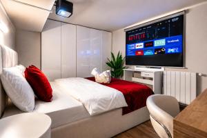 a bedroom with a bed with a flat screen tv at Vake Dream Duplex in Tbilisi City