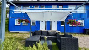 a blue house with a couch under a white canopy at Face Of North in Gratangen