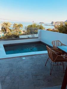 a swimming pool with a table and chairs on a patio at Salt and stone suites in Vrachonisída touArchangélou