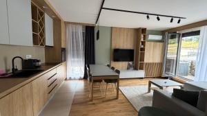 a kitchen and living room with a table and a couch at DivciCasa apartments Divčibare in Divčibare