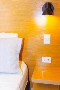 a bedroom with a bed and a light on a wall at Hotel Qamiri in Arica
