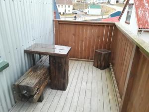 a bench and two logs on a balcony at Rólegt in Ísafjörður