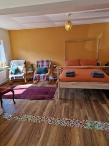 a bedroom with a bed and a couch and a chair at Fairways in Melrose +2 photos