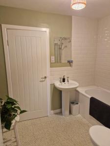 a bathroom with a sink and a tub and a toilet at Fairways in Melrose