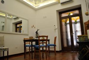 a dining room with a table and chairs and a mirror at B&B Palazzo Sant'Alfano in Catania