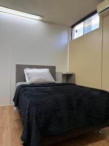 a bedroom with a bed with a black blanket at LOFT Centrico in Ciudad del Este +5 photos